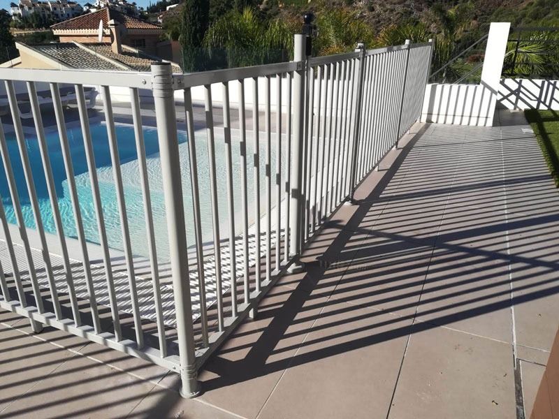 Cerramiento de barrotes junto a una piscina